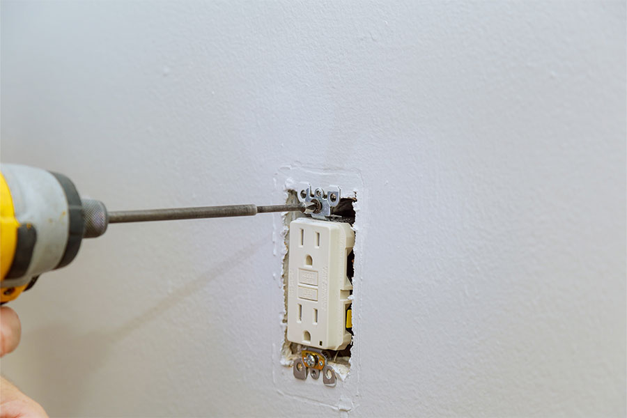 Securing outlet to wall
